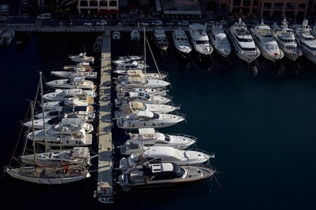 A large number of luxury white yachts. Pier with many large and small yachtsの写真素材