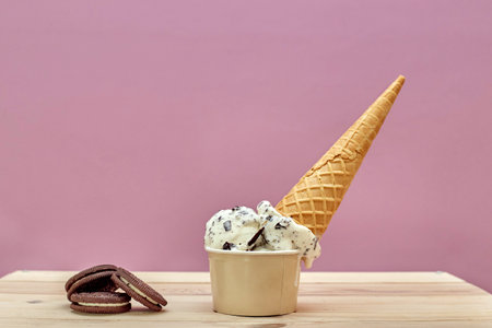 Upside down ice cream container on a pink background.