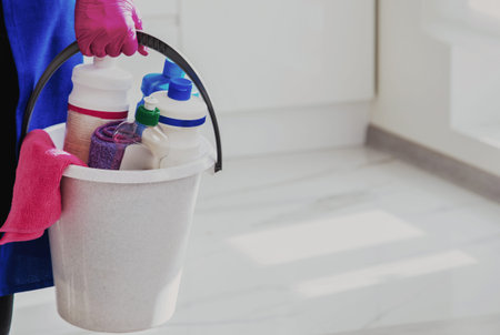 Bucket of detergents. Against the background of a white beautiful modern kitchen