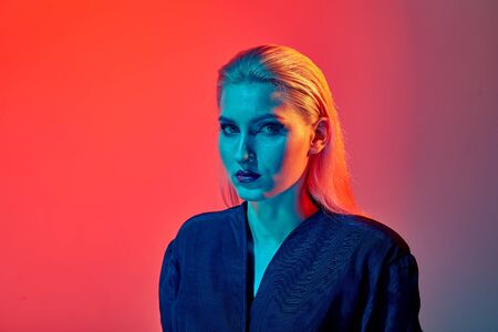 Sexy look of a young girl in the frame. Bright maquige. Bright lipstick. Neon lighting.の写真素材