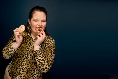 Fat girl eating fast food with an appetite. In the hand, a bitten donut. Leopard blouse. Overweight....