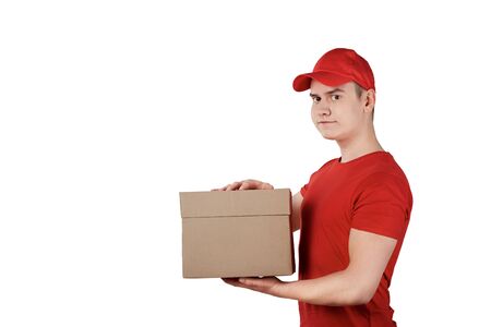 A young guy from the delivery service with a parcel, a box in his hands. Bela background.の写真素材