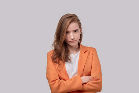 Portrait of a young offended girl with a sad face. Human emotions. Gray background.の写真素材