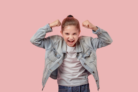 An angry screaming girl swears and raised her hands up. Pink background.