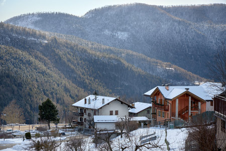Large beautiful house standing among the forests and hills. Christmas card.