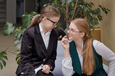 Young beautiful girls with glasses chat and discuss work. Coffee break.の写真素材
