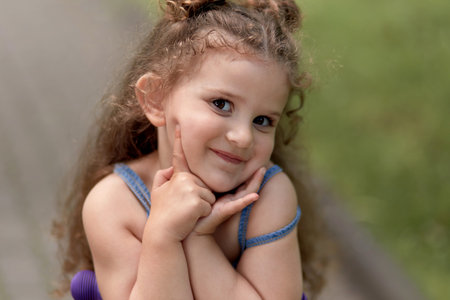 Portrait of a cute beautiful girl with long dark hair. Looking into the camera.