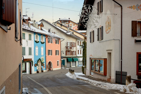 View of a narrow road among colorful houses. The city is decorated for Christmas. Winter holidays.
