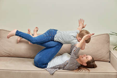 Time spent with family. Mom plays with her little son. The parent plays with the child at home.の写真素材