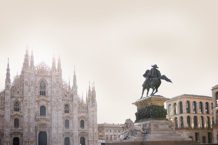 Building Duomo on a bright sunny day. There is a tall monument in front. Milan Italy 08.2020