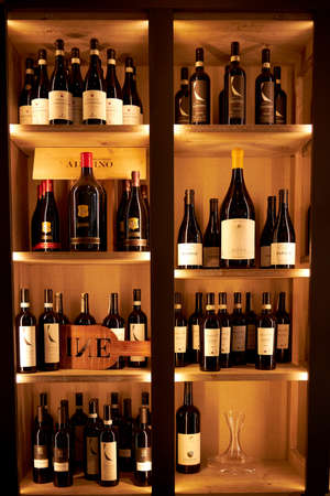 Large beautiful wooden shelf with wine in the restaurant. Vertical phono. Large selection of varied wines. Milan Italy. 08.2020のeditorial素材