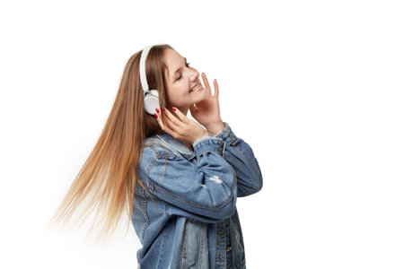 Young women listen to music with headphones. Flying blonde hair. White isolated background.