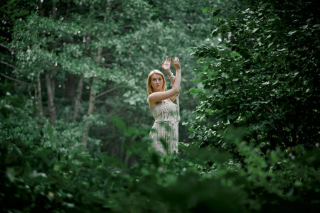 Beautiful young woman doing yoga in nature. Clothing made of eco-friendly materials in beige and...