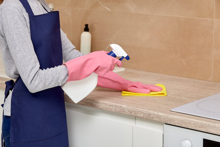 Cleaning the kitchen with spray and chemicals. Without a face. Home routine. Professional cleaning.