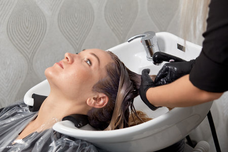 Wash your hair in the washbasin in a beauty salon. Professional hair care products. Hair coloring.の写真素材