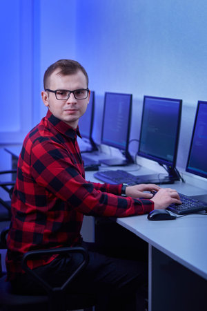 Vertical photo of a man with glasses for vision. Prescribes the code on the computer. The work of a...