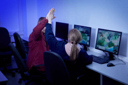 A young man and a woman play on the same team and enjoy the victory. High-five gesture.の写真素材