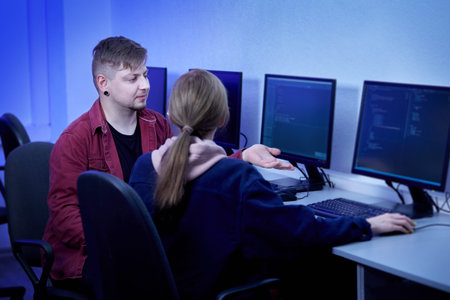A male teacher communicates with a young woman and discusses the work. Esports Player training....