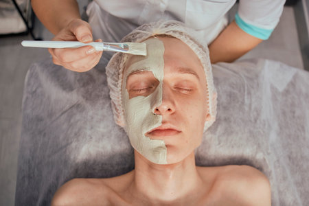 Top view of a mans face with green natural clay. Natural cosmetics. Beauty salon.