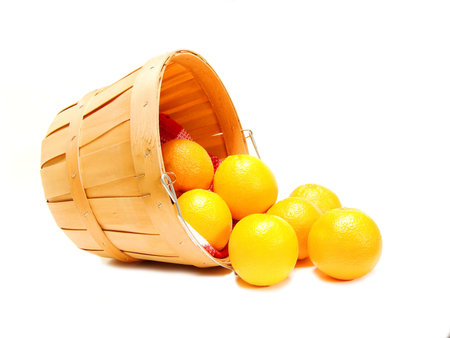 Oranges spilling out of a wooden farmer's basket, on whiteの写真素材