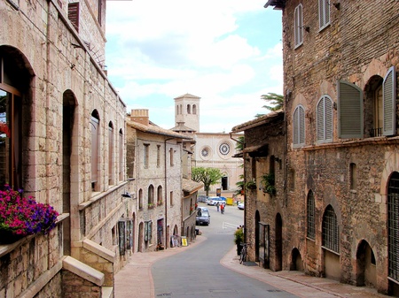 Medieval street in Assisi, Italy and the church San Pietroの写真素材