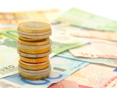 Single stack of coins with bank notes in the background の写真素材