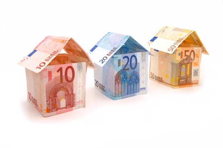 Three houses made of money on a white background の写真素材