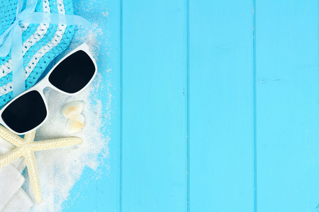 Summer side border of beach items and sea shells on blue wooden backgroundの写真素材