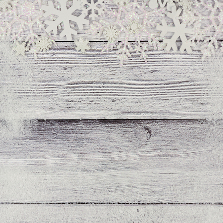 Christmas snowflake top border with snow frame on rustic white wood backgroundの写真素材