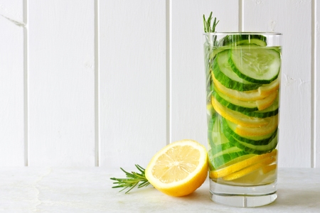 Glass of detox water with lemon, cucumber and rosemary with a white wooden backgroundの写真素材
