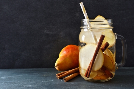 Pear, ginger, cinnamon detox water in a jar against slateの写真素材