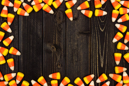 Halloween candy corn frame on an old dark wood background