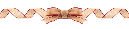 Long Christmas border with burlap bow and ribbon with red trim isolated on a white backgroundの写真素材