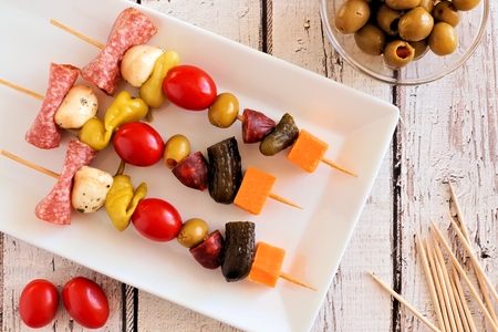 Skewer appetizers with cheese, meat and pickles overhead view on a white wood backgroundの写真素材