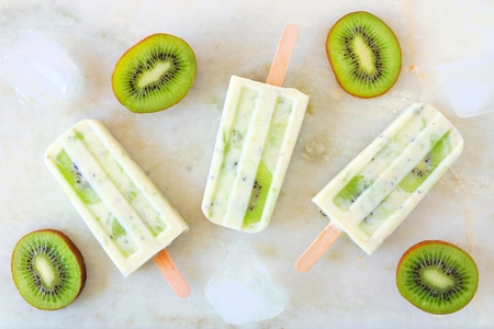 Kiwi vanilla yogurt ice cream pop on a bright marble background. Top view scene.の写真素材
