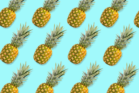 Colorful fruit pattern. Pineapples on a pastel blue background. Top view.