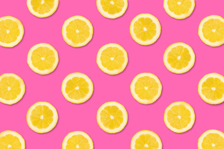 Colorful fruit pattern. Lemon slices on a pastel pink background. Top view.
