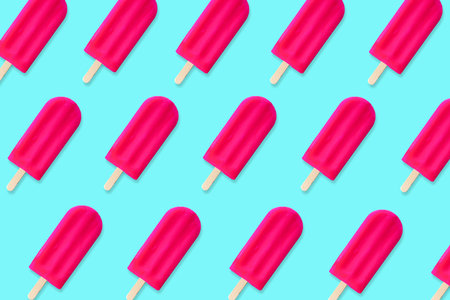 Colorful summer pattern. Bold pink ice cream pop on a pastel blue background. Top view.