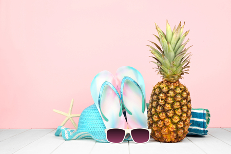 Summer vacation beach accessories against a pastel pink backgroundの写真素材