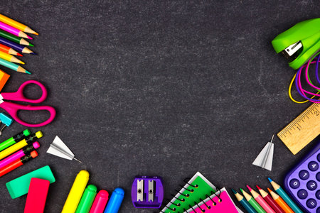 School supplies border frame, top view on a chalkboard background with copy space, back to school...
