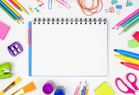 Blank coil notebook with school supplies frame against a white background, back to school conceptの写真素材