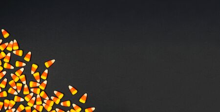 Halloween candy corn corner border banner on a black background with copy spaceの写真素材