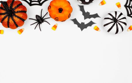 Halloween top border flat lay of pumpkins, candy and decor, over a white backgroundの写真素材