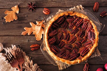 Homemade autumn pecan pie, top view table scene over a rustic wood backgroundの写真素材