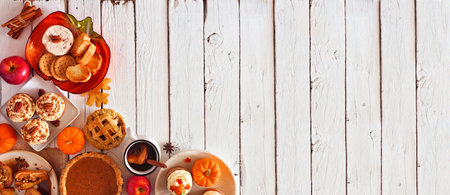 Autumn table scene corner border banner of pies, appetizers and desserts, top view over a white wood background with copy spaceの写真素材