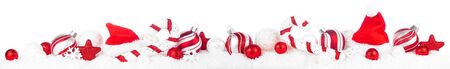 Christmas border of red and white decorations in snow isolated on whiteの写真素材