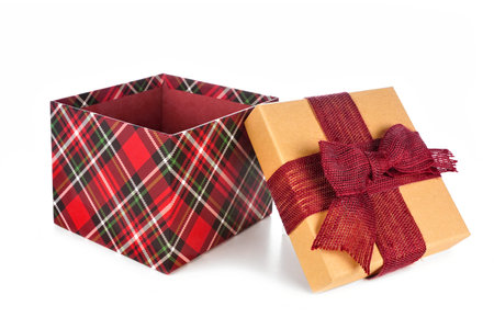 Red plaid wrapped open Christmas gift box with lid and bow, side view isolated on white