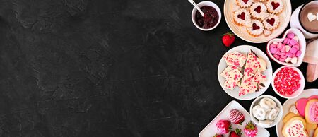 Valentines Day side border banner with a selection of sweets and cookies, top view over a dark stone  with copy spaceの写真素材