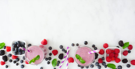 Banner with healthy mixed berry smoothie bottom border over a white marble background with copy...