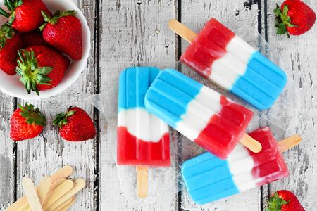 Summer red, white and blue fruit ice pop, table scene over rustic white woodの写真素材